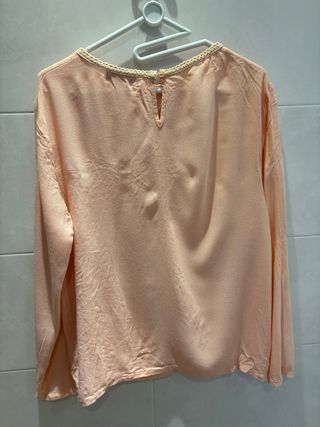 Blusa ricamata a maniche lunghe rosa pesca.