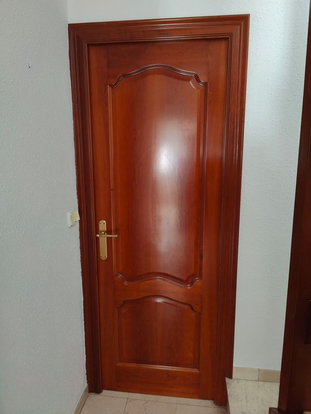 Puerta de madera maciza color cerezo con molduras