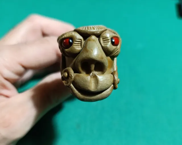Scultura in legno con occhi rossi