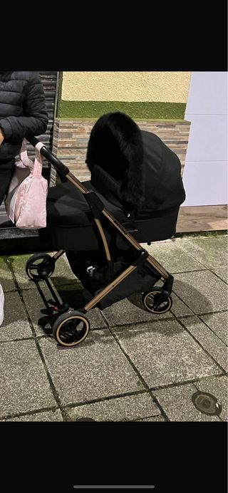 Carro de bebé negro con detalles dorados