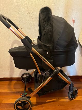 Carro de bebé negro con detalles dorados
