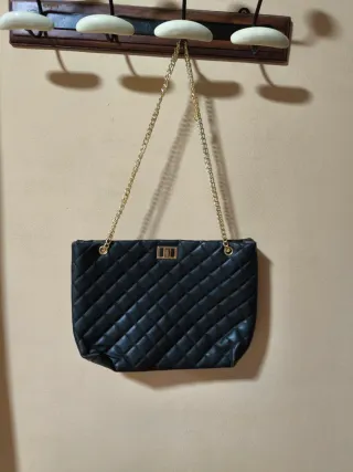 Bolso negro acolchado con cadena dorada
