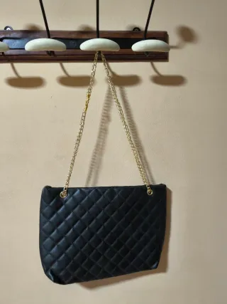Bolso negro acolchado con cadena dorada