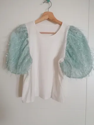 Camiseta blanca con mangas de plumas