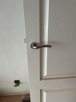 Puerta de madera blanca con manilla