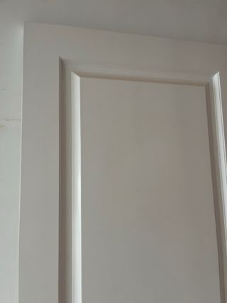 Puerta de madera blanca con manilla