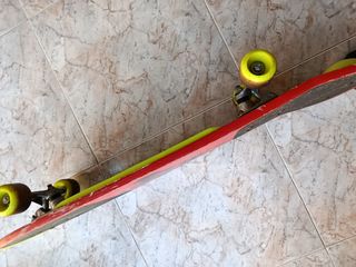 Monopatín rojo con diseño de patinador