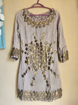 Vestido gris con adornos color cobre