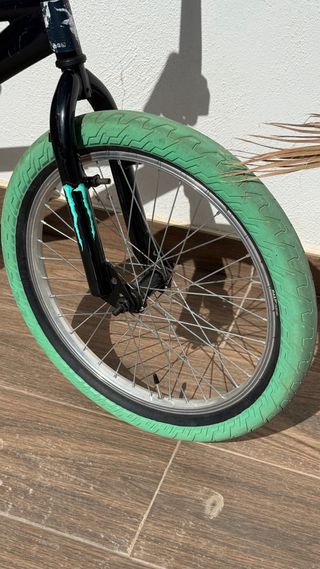 Bicicleta BMX negra con ruedas verdes