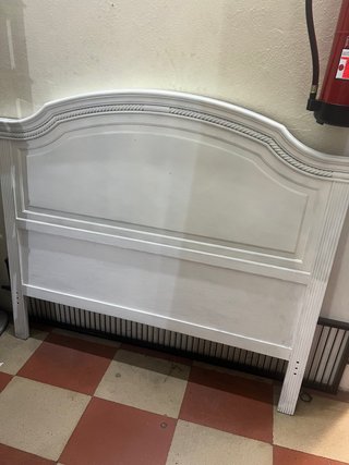 Cabecero de cama de madera pintada en blanco.