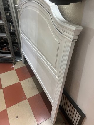 Cabecero de cama de madera pintada en blanco.