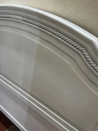 Cabecero de cama de madera pintada en blanco.