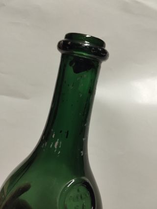 Botella de vidrio verde antigua
