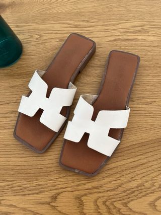 Sandalias planas blancas y marrones