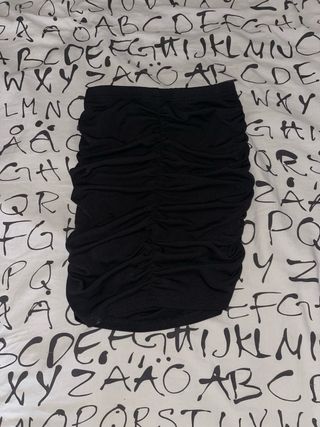 Falda corta negra ajustada con fruncido.