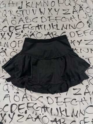 Falda corta negra con volantes.
