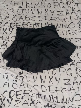 Falda corta negra con volantes.
