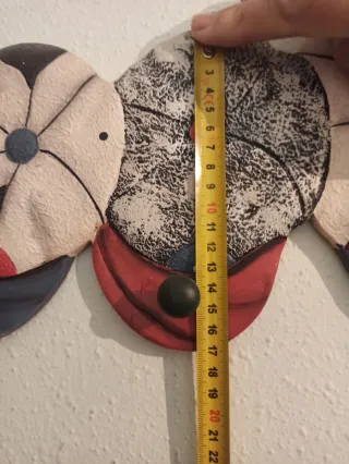 Percha de pared con diseño de gorras