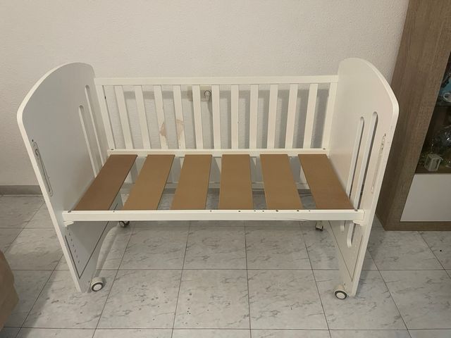 Cuna de bebé blanca con protector