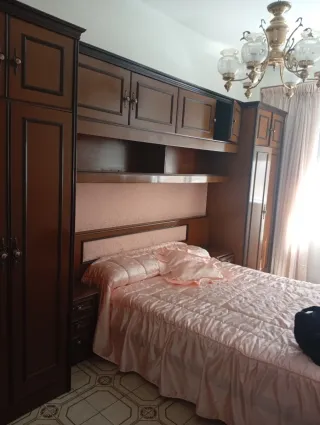 Mobili ad arco con due tavoli e letto matrimoniale