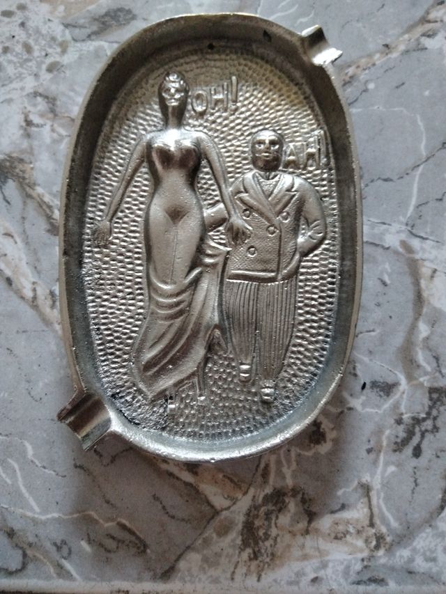 Curioso posacenere con figure in rilievo