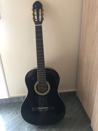 Guitarra española negra de regalo la funda negra.