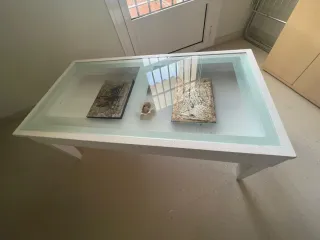 Mesa de centro de salón con tapa de cristal.