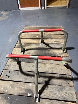 Barrera de parking metálica con protecciones rojas