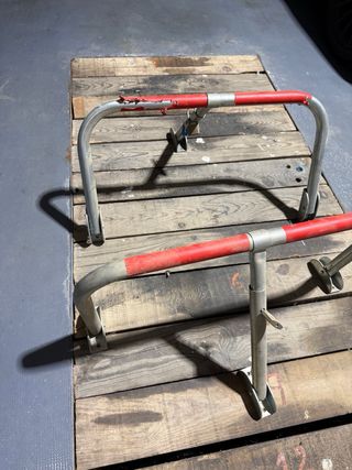 Barrera de parking metálica con protecciones rojas