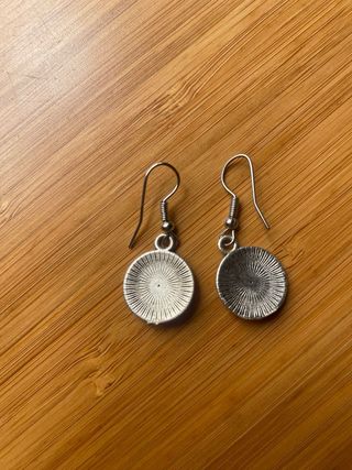 Pendientes redondos plateados con detalles verdes