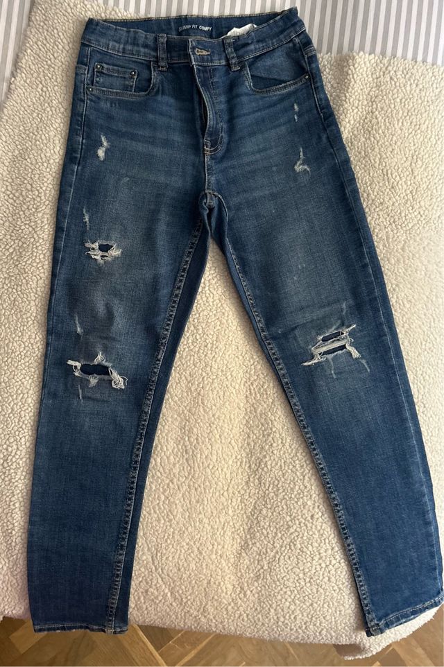 Pantalón vaquero niño azul con rotos. Buen estado.