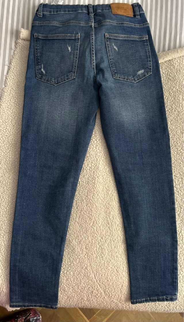 Pantalón vaquero niño azul con rotos. Buen estado.