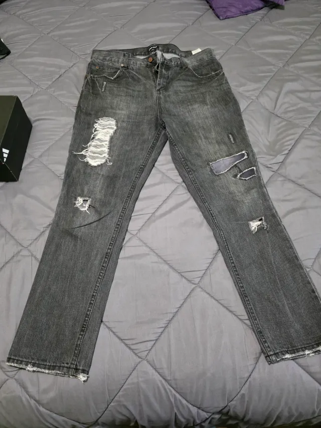 Pantalones vaqueros hombre grises desgastados.