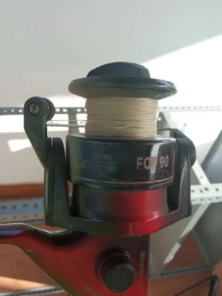 Caña de pescar con carrete rojo