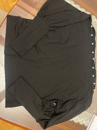 Camiseta negra con perlas y hombros descubiertos