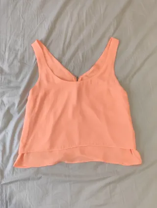 Blusa salmón con capas en la parte de atrás.