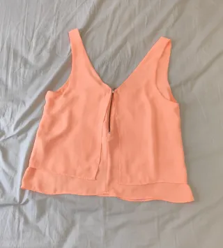 Blusa salmón con capas en la parte de atrás.