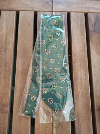 Corbata verde con escudos dorados.