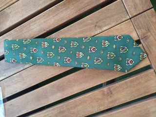 Corbata verde con escudos dorados.