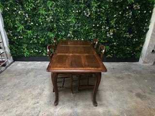 Mesa de comedor antigua de madera con sillas.