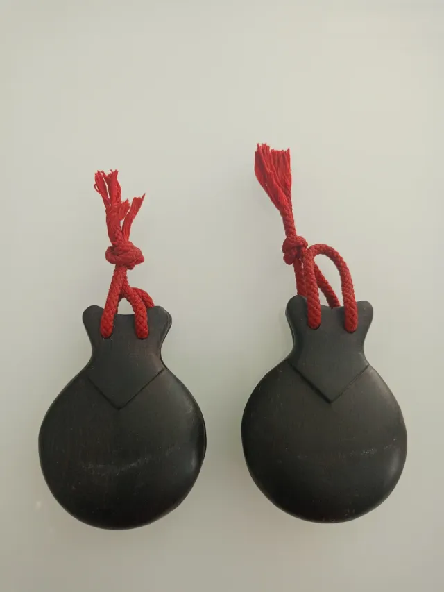 Castañuelas de madera con cordón rojo