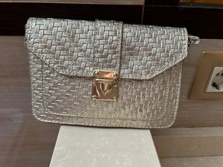 Bolso dorado tejido con cierre metálico