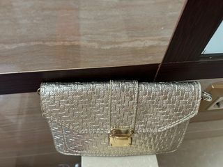 Bolso dorado tejido con cierre metálico