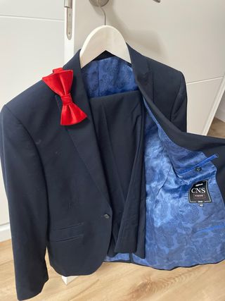 Traje azul marino con pajarita roja
