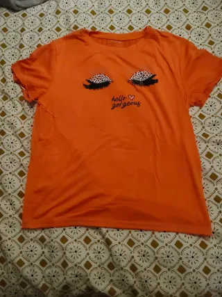Camiseta naranja con ojos y texto