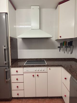 Muebles de cocina blancos con tiradores rojos