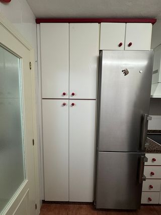 Muebles de cocina blancos con tiradores rojos