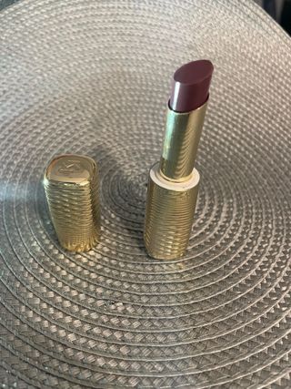 Labial dorado con tapa morada