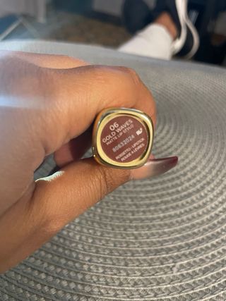 Labial dorado con tapa morada