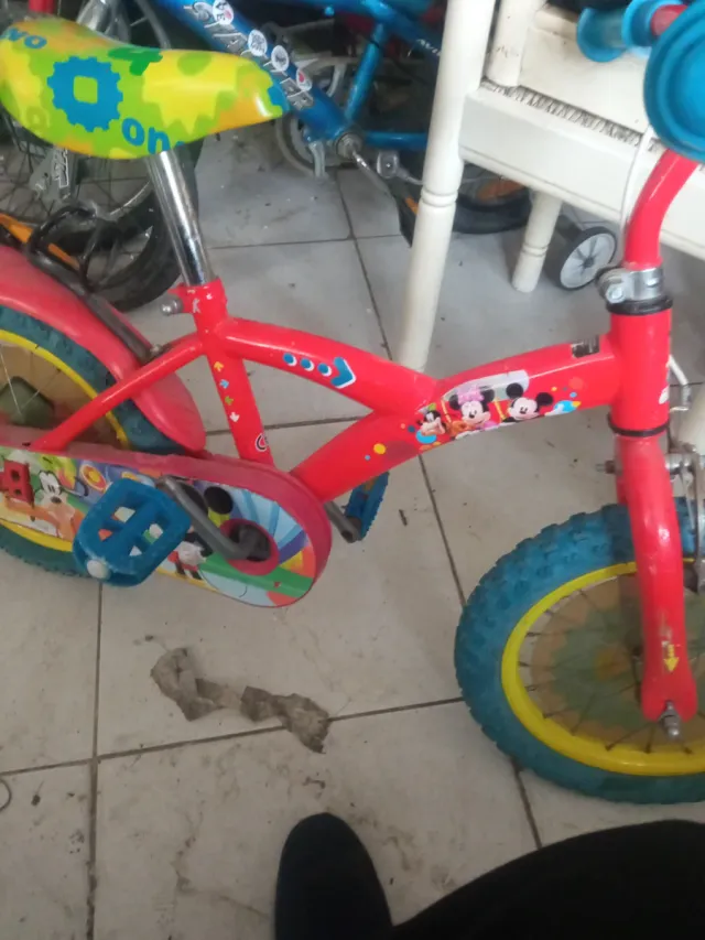 Bicicleta infantil roja con ruedas azules